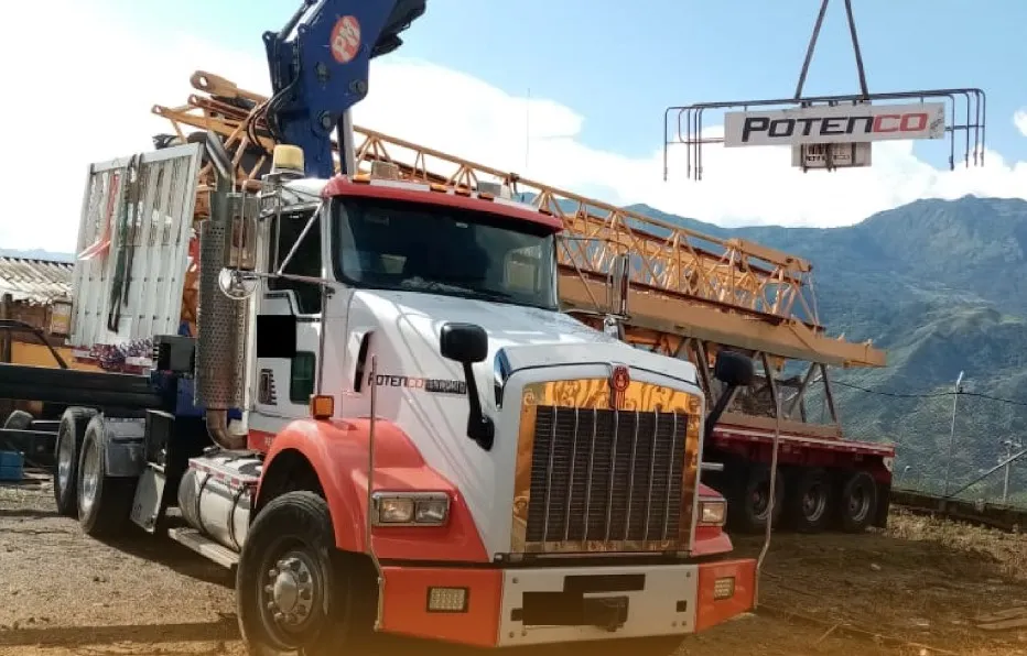 camion con brazo articulado descargando torre grua en obra de construccion